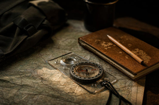 baseplate compass on topographic map for wilderness survival navigation